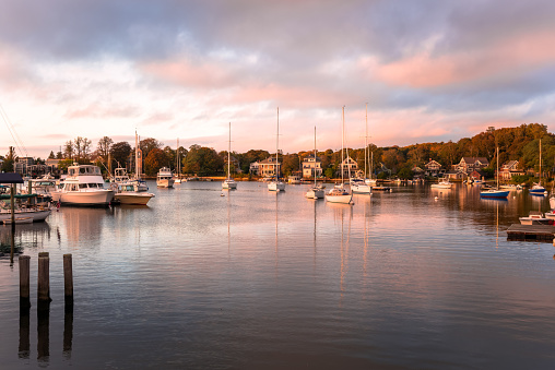 Beautiful natural harbour with anchored sailboats at sunset in autumn. Falmouth, Cape Cod, MA, USA.